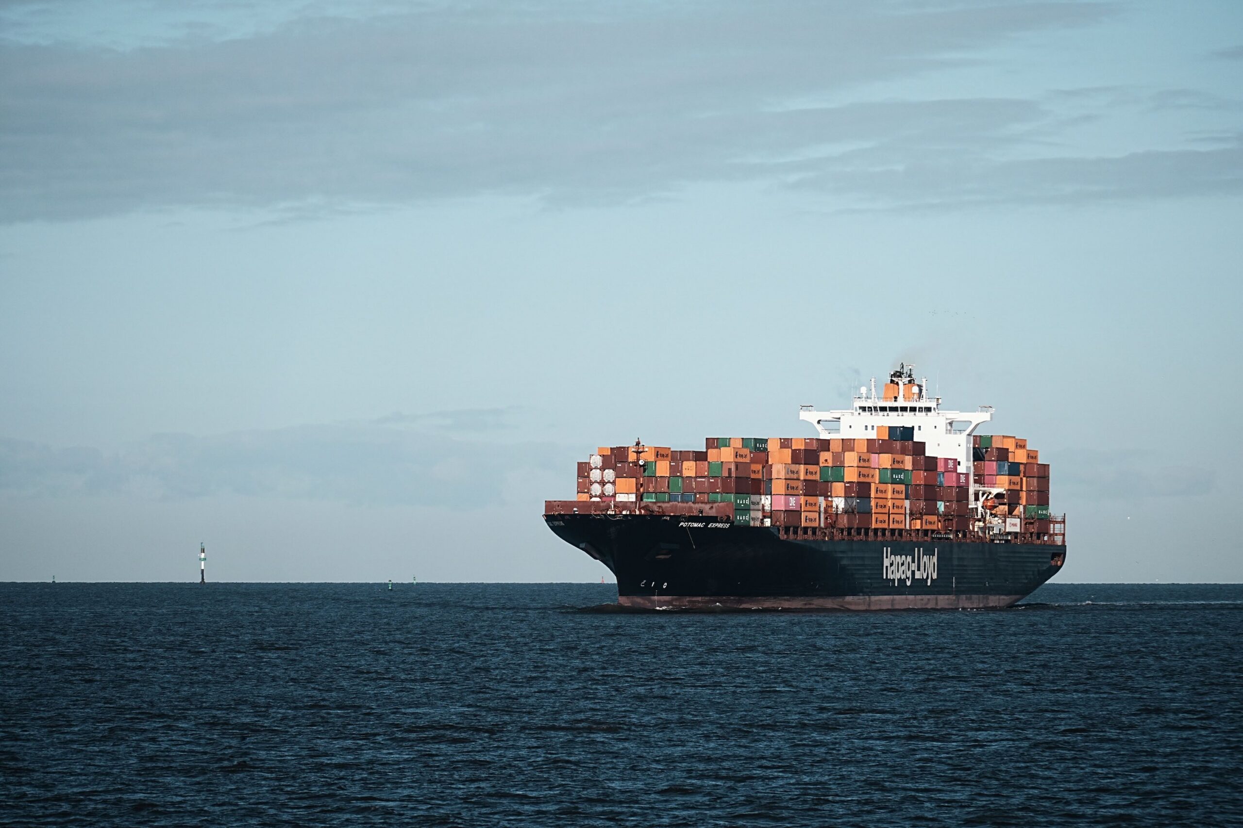 Hapag-Lloyd container vessel loaded with shipping containers on a calm sea under sunny weather